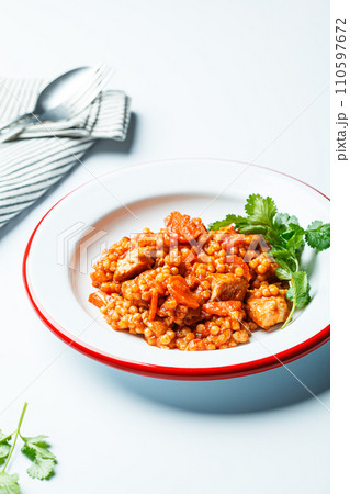 Ptitim with chicken, vegetables and cilantro, white background. Traditional Israeli food. 110597672