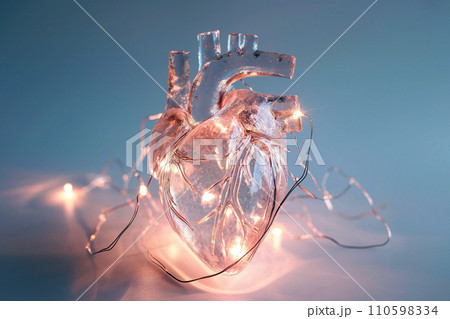 Human heart made of glass or ice with light garland. Anatomically correct heart on blue background. Glowing frozen heart, love and romantic concept 110598334