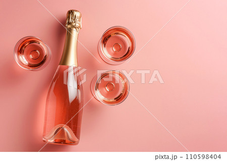 Champagne bottle with glasses on pastel background. Party background with sparkling wine, bubbling rose champagne, celebration concept. Girls only party, bachelorette, hen night. Minimal composition Champagne bottle with glasses on pastel background. Party background with sparkling wine, bubbling rose champagne, celebration concept. Girls only party, bachelorette, hen night. Minimal composition 110598404