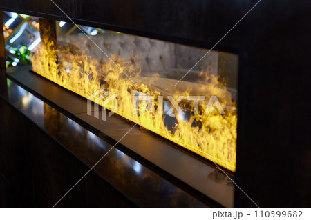 Electric log fireplace. Restaurant showcase decorated with artificial heater. Exterior design. 110599682