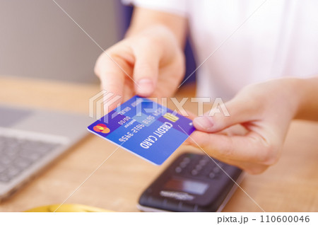 クレジットカードで支払いをする女性 110600046