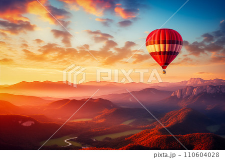 Colorful hot air balloon over desert mountains at sunset 110604028
