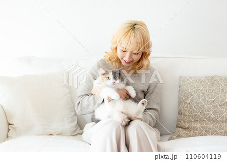 猫を抱っこする日本人女性 110604119