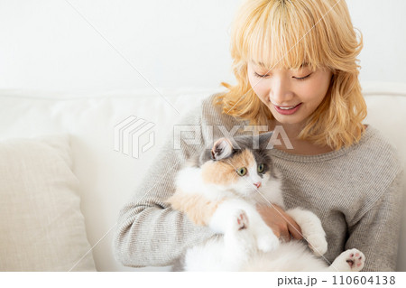 猫を抱っこする日本人女性 110604138