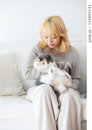 猫を抱っこする日本人女性 110604141