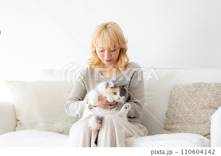 猫を抱っこする日本人女性 110604142
