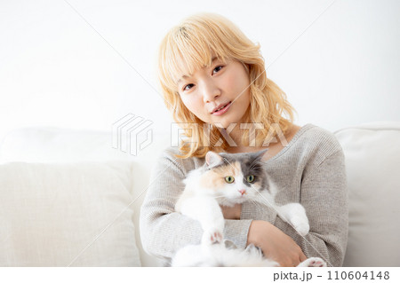 猫を抱っこする日本人女性 110604148
