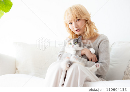 猫を抱っこする日本人女性 110604158