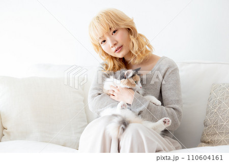 猫を抱っこする日本人女性 110604161