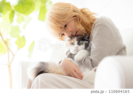 猫を抱っこする日本人女性 110604165
