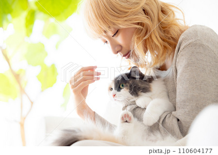 猫を抱っこする日本人女性 110604177