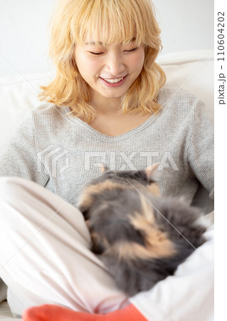 猫を抱っこする日本人女性 110604202