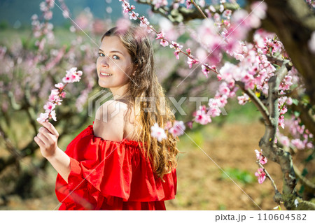 Happy girl in the spring garden peach in red dress 110604582