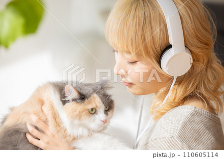 猫を抱っこする若い女性 110605114