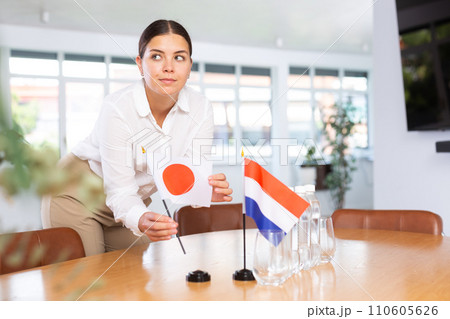 Businesswoman arranging the flags of Japan and Netherlands for presentation and negotiations 110605626