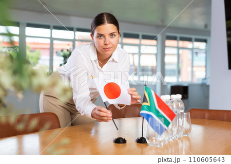 Young lady sets miniatures flags of South Africa and Japan for international negotiations Young lady sets miniatures flags of South Africa and Japan for international negotiations 110605643