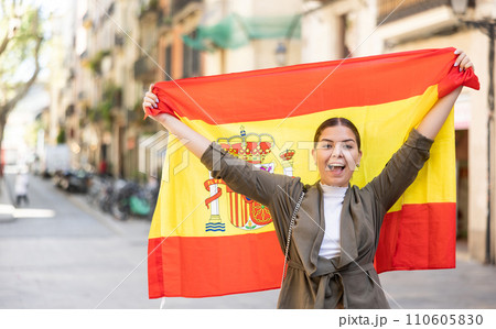 Young smiling woman holding Spain flag Young smiling woman holding Spain flag 110605830