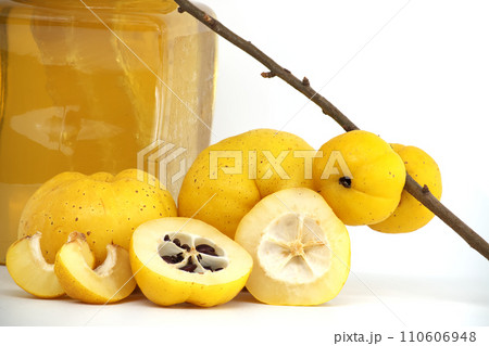 Bright golden-yellow quince fruits and honey on white Bright golden-yellow quince fruits and honey on white 110606948