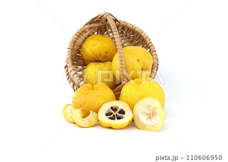 Wicker basket with fresh yellow quince fruits over white 110606950