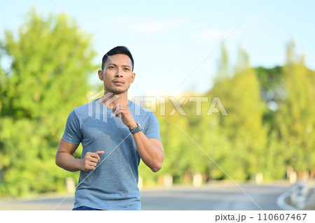 Shot of young athletic man running in city park on a sunny day. Healthy active lifestyle concept 110607467