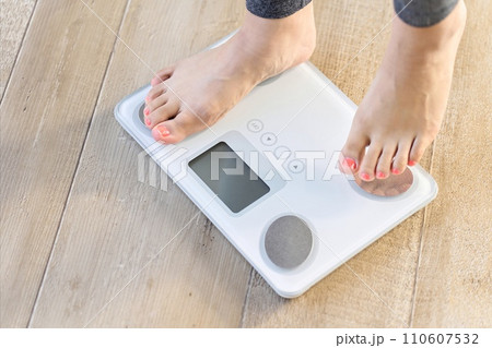 体重計に乗る女性の足元 体重計に乗る女性の足元 110607532