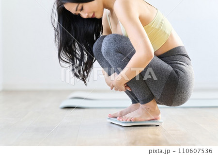 体重計に乗るアジア人女性 体重計に乗るアジア人女性 110607536