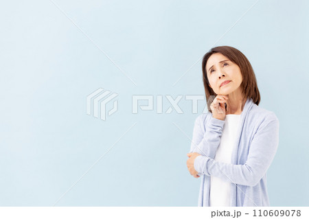 悩むシニア女性 ブルーバック 悩むシニア女性 ブルーバック 110609078