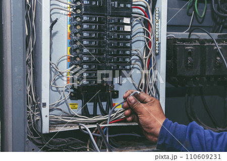 Inspector men hands working switchboard machinery maintenance service. Electrical mechanic technician check wire electric cabinet. Electrician circuit repair voltage operation. Men hands fix breaker Inspector men hands working switchboard machinery maintenance service. Electrical mechanic technician check wire electric cabinet. Electrician circuit repair voltage operation. Men hands fix breaker 110609231