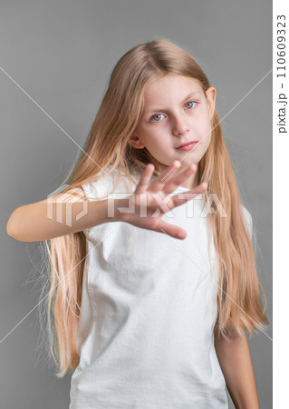 A little girl showing a sign of protest or refusal with her hand. 110609323