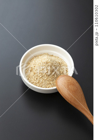 器に入ったすりごまと木製スプーン 黒バック 器に入ったすりごまと木製スプーン 黒バック 110610302