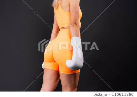 Woman boxer in gloves training on yellow and dark studio background Woman boxer in gloves training on yellow and dark studio background 110611866