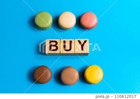 Colorful cake macaron or macaroon on blue background. Flat lay, top view, copy space. Word Buy Colorful cake macaron or macaroon on blue background. Flat lay, top view, copy space. Word Buy 110612017