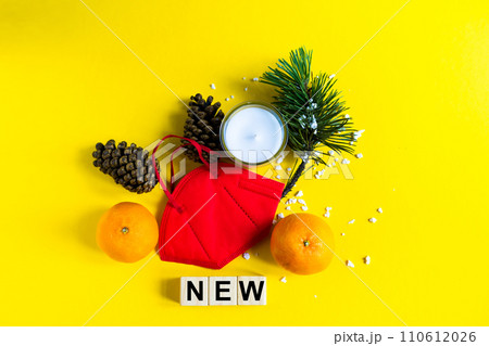 Tangerines lie in a medical mask among the branches of the Christmas tree, word New wooden cubes Tangerines lie in a medical mask among the branches of the Christmas tree, word New wooden cubes 110612026