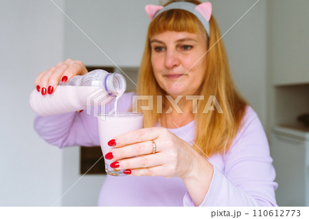 Middle aged woman drinking yogurt 110612773