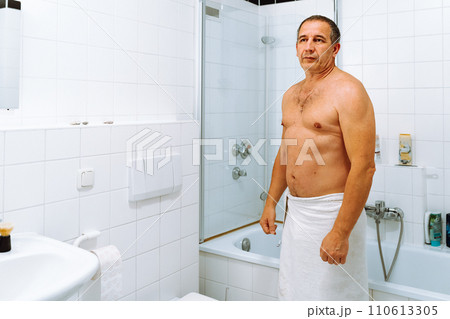 Portrait man after shower in bathroom with white tiled floor and walls 110613305