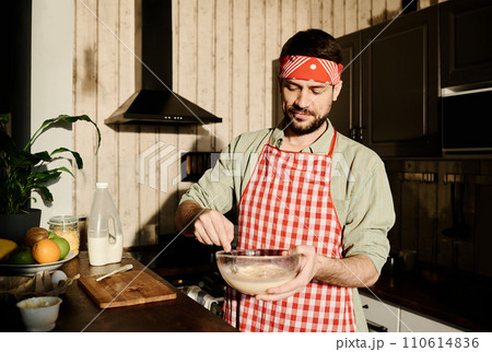 Young man cooking omelet for breakfast 110614836