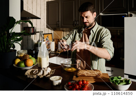 Guy preparing omelet for breakfast Guy preparing omelet for breakfast 110614850