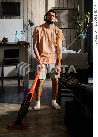 Man cleaning floor with home appliance Man cleaning floor with home appliance 110614947