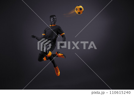 African young man, soccer player in mid-kick with selective orange coloring, illustrating movement and focus. Dynamic image of athlete 110615240
