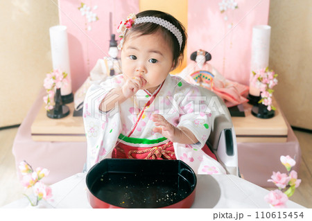 初節句のお食事　手掴み食べする赤ちゃん 110615454