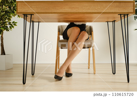Female legs in pantyhose under the office table 110615720