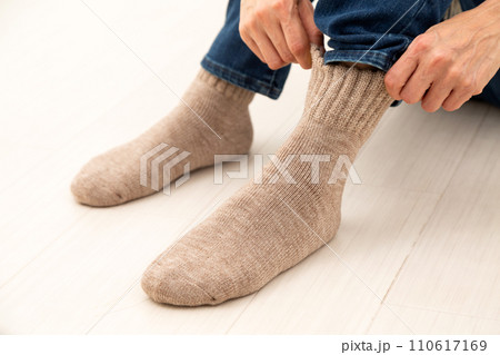 冬物の厚手靴下を履くミドル女性の足元 110617169