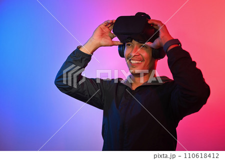 Portrait of smiling millennial man VR headset. Technology, innovation and cyberspace concept Portrait of smiling millennial man VR headset. Technology, innovation and cyberspace concept 110618412