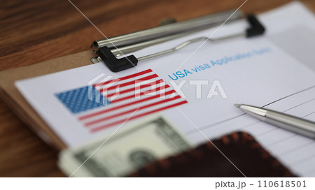 Ballpoint pen and dollar bills lying on documents for applying for visa closeup Ballpoint pen and dollar bills lying on documents for applying for visa closeup 110618501