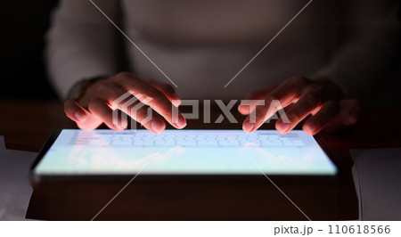Female fingers are typing on tablet screen at night Female fingers are typing on tablet screen at night 110618566