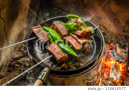 ワイルドに焼くステーキ Grill a steak over an outdoor ワイルドに焼くステーキ Grill a steak over an outdoor 110618577