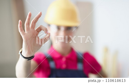 Smiling woman builder holds thumbs up in gesture ok Smiling woman builder holds thumbs up in gesture ok 110618613