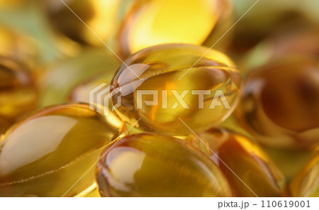 Golden transparent capsules in organic packaging closeup 110619001