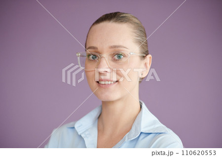 Portrait of positive entrepreneur in glasses standing against lilac background Portrait of positive entrepreneur in glasses standing against lilac background 110620553