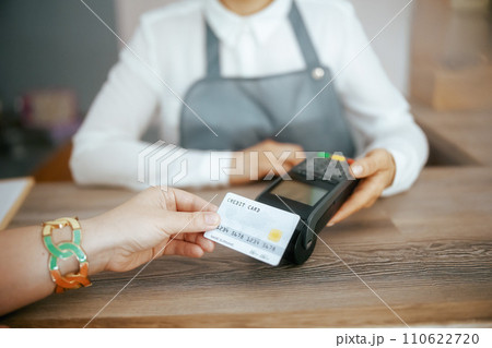 Hair salon employee accepting credit card payments via terminal Hair salon employee accepting credit card payments via terminal 110622720